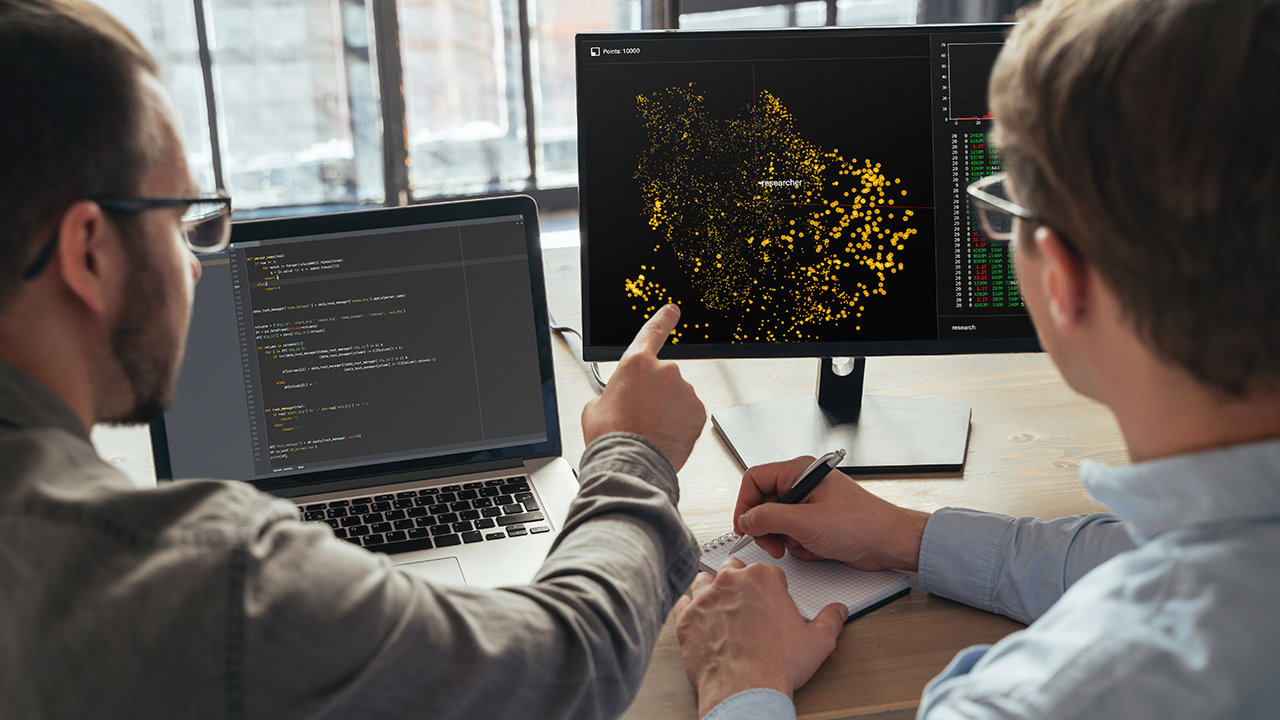 Two men analyzing data on a laptop, collaborating on exploratory data analysis and visual storytelling using graphs and charts.